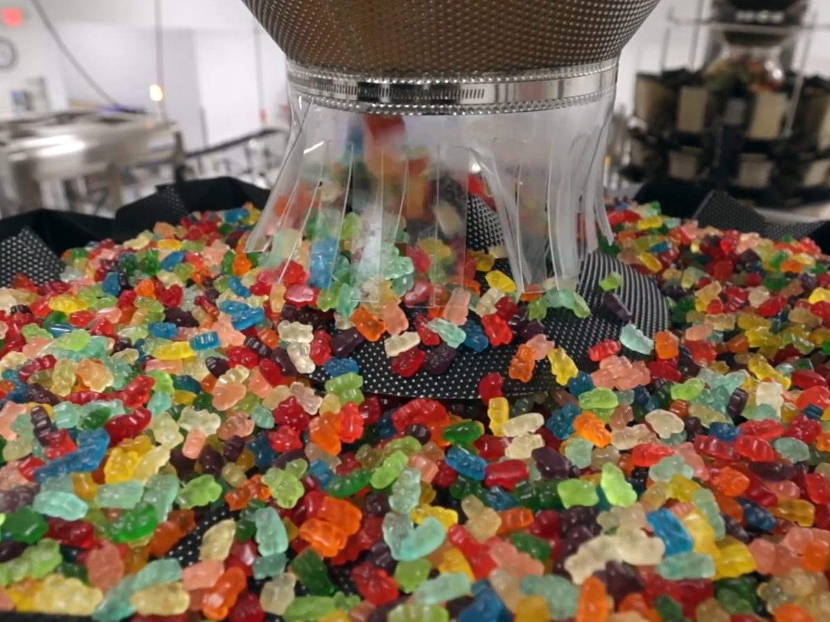 L'Orenta's own filling line: a stainless steel multi-head weigher dispensing gummy candies into packages
